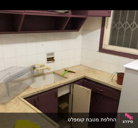 מטבח עם ארונות סגולים, כיור ומטלית צהובה